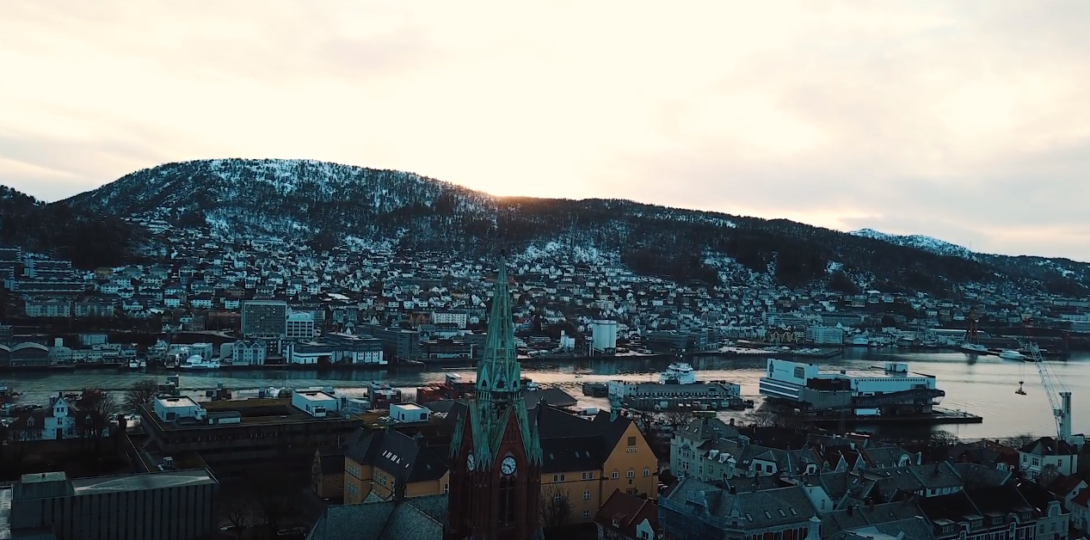 An aerial view of a city with mountains and a river visible