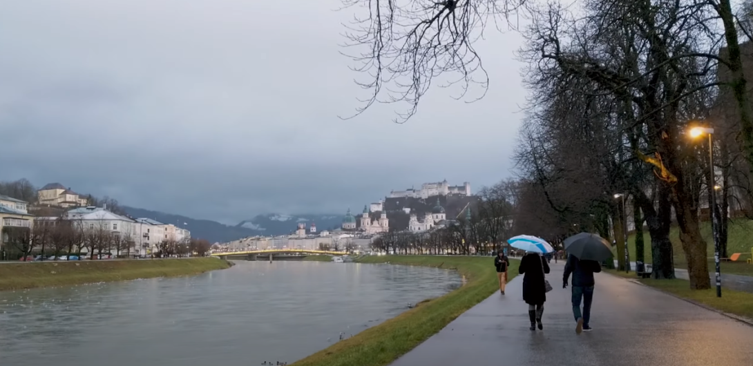 A photo of a park with a cloudy sky and a lake