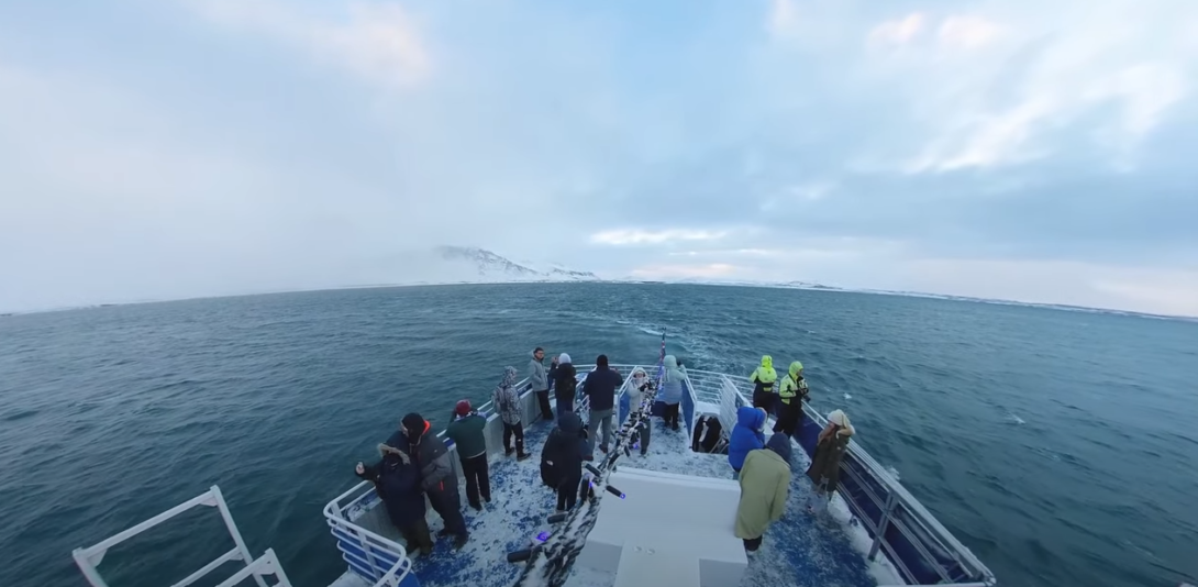 people sailing on a boat in the middle of the ocean