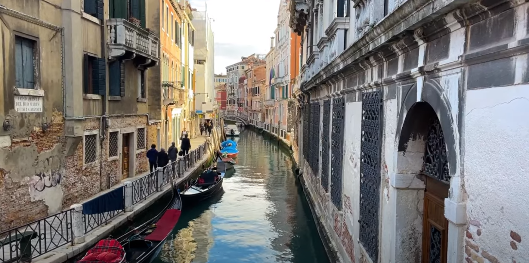 A river surrounded by buildings and boats on the sides