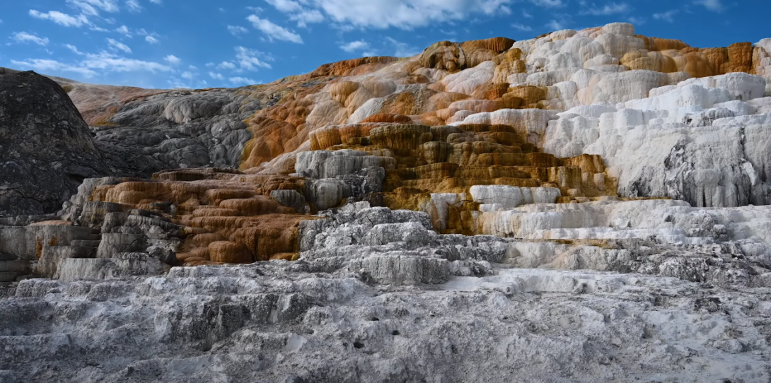 An image of Mammoth Hot Springs seen from a distance, displaying its shades of brown, white, and gray