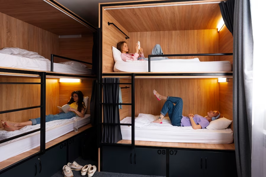 A room with two bunk beds, each occupied by girls lying down