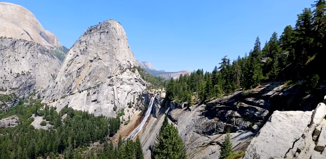 Rocky mountain with trees and waterfall