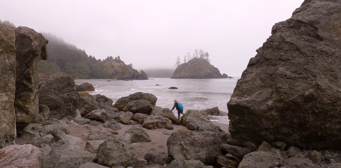 Big visible rocks and a lake, with a girl nearby