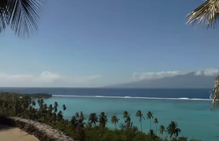 A distant view of the sea with visible trees and mountains