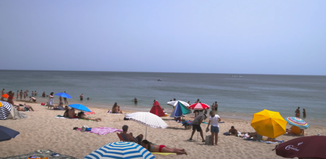 Beach scene with people lounging on the sand and beach umbrellas