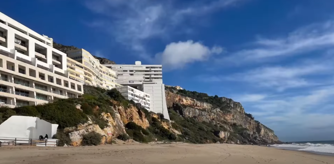 Rock formation with buildings atop, near the sea