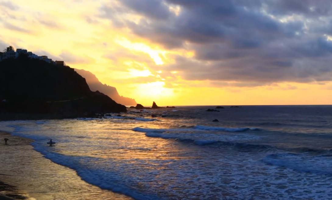 shipwreck beach - ocean, waves, mountains behind, and cloudy sky