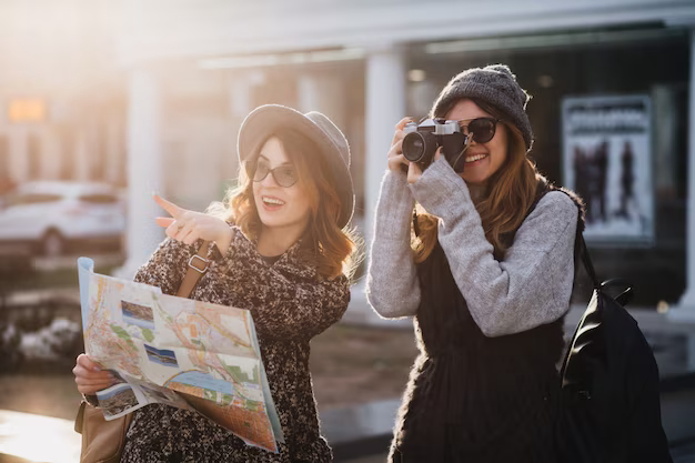 Women travel together holding a map and a camera