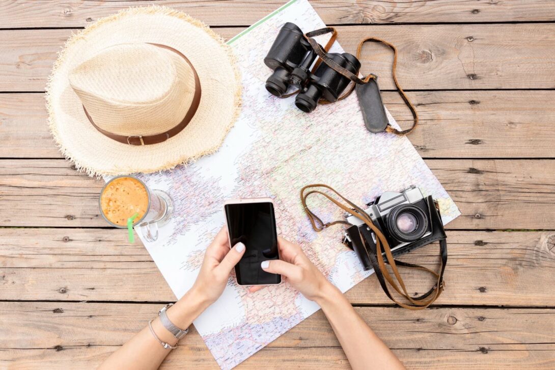 Top view of woman holding her phone and planning trip